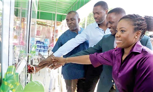 Kenny Tei Kwabena (2nd from right), CEO, Floke Company Limited, being assisted by Bishop Ransford Owusu (left), Anagkazo Assembly, Lighthouse Chapel, to cut the tape to open the facility. With them are other partners of the facility. 